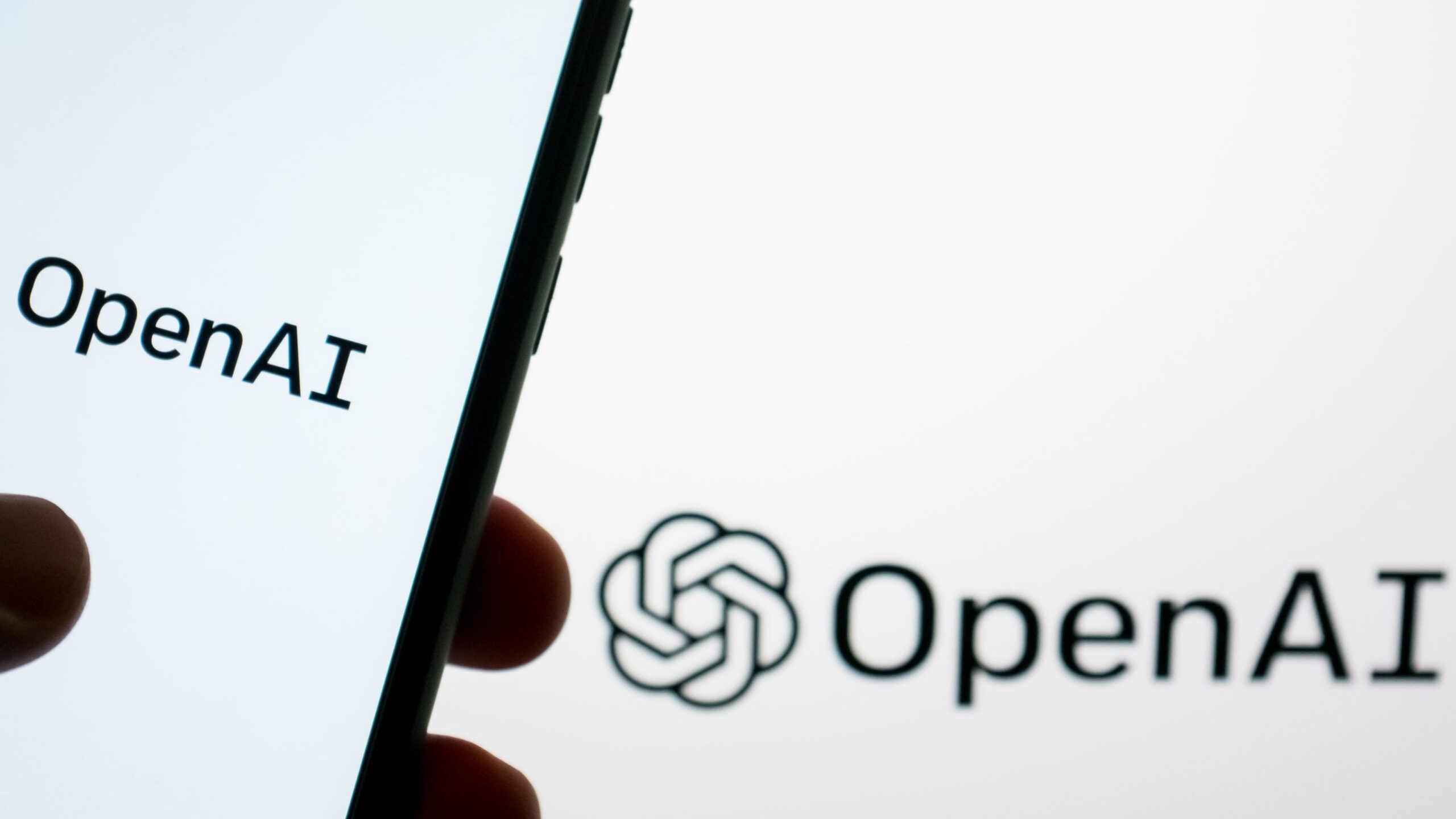 2024年5月21日，在希腊雅典，OpenAI的标志分别显示在智能手机屏幕和电脑屏幕上。
